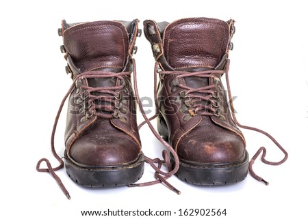 Worn out old hiking or work boots isolated over white background
