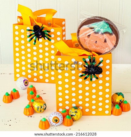 Halloween children\'s treat bags decorated with spiders and filled with chocolates and candy.