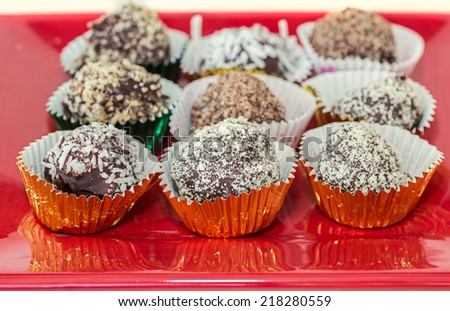 Homemade chocolate truffles with different coatings such as coconut, crushed almonds or hazelnuts or walnuts. Each in its own foil cup.