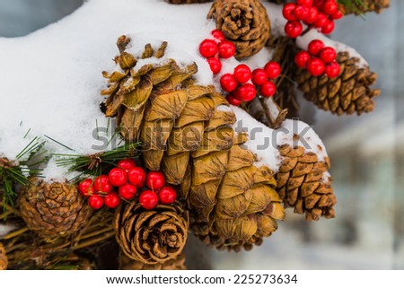 Detail of an outside Christmas cone wreath covered in snow