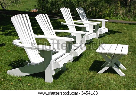 A row of white lawn chairs positioned on the lawn.
