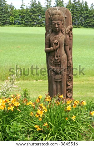Thai themed garden statue of a mass produced goddess in a country garden.