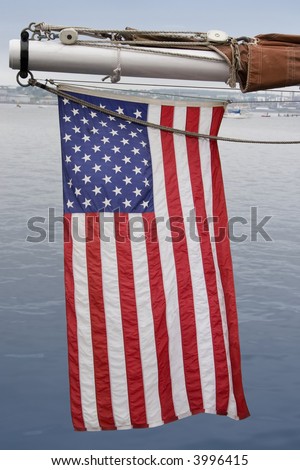 An American flag hanging off the outhaul on a sailing ship.
