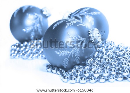 Blue toned scene of Christmas ornaments and garland.