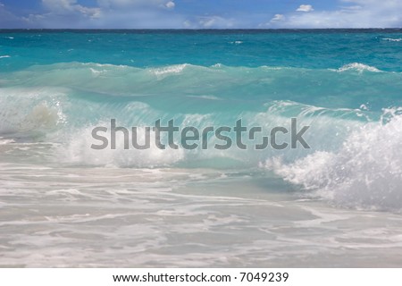 A wave rolls in onto a Caribbean beach.