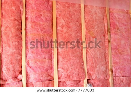 Bats of pink fiberglass insulation used in home construction to conserve heat and add energy efficiency.