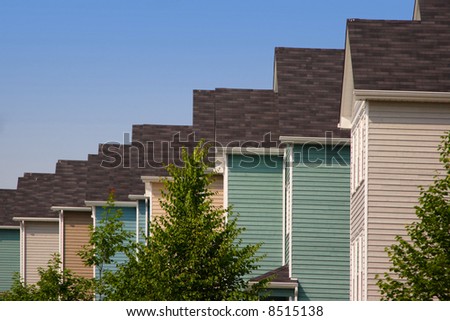 A row of pastel colored new family townhouses.