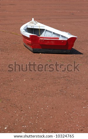 Small Red Wooden Row Boat On The Beach At Low Tide. Stock Photo 
