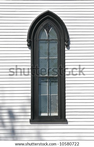 An arched window on the side of a church.