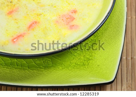 A bowl of hearty homemade soup in a ceramic bowl on a place mat.
