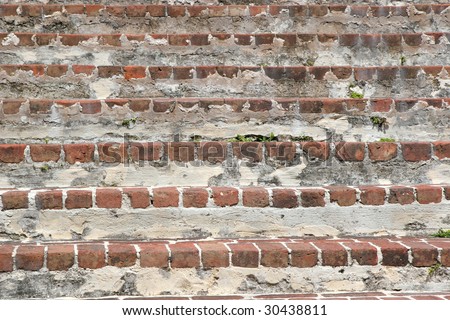 A series of steps in an old brick staircase.