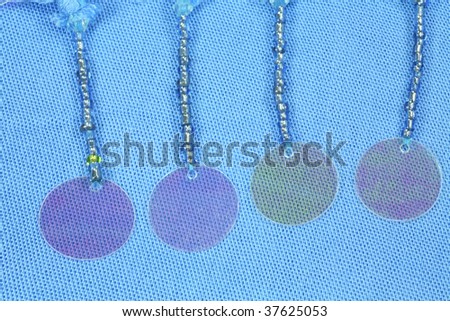 Details of a summer beach wrap showing beads and shiny plastic spangles.