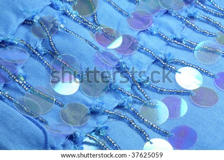 Details of a summer beach wrap showing beads and shiny plastic spangles.