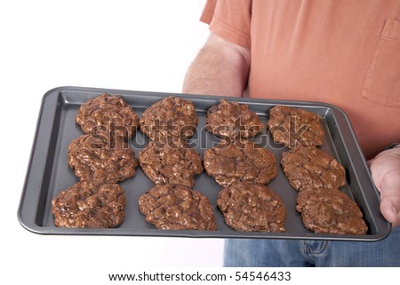The cook holding his pan of cookies. Triple the chocolate in these decadent homemade chocolate cookies for gourmets. Cocoa, chocolate and chocolate chips.