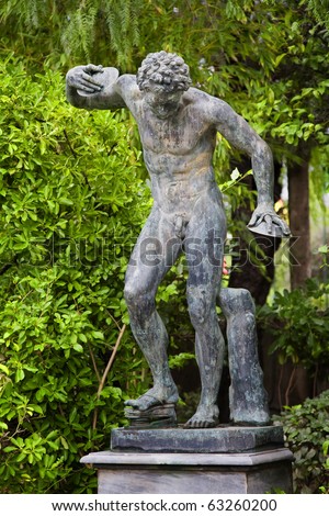 A replica of an ancient greek statue showing a disk thrower olympic athlete in the gardens of the Achillion Palace on the Greek island of Corfu.
