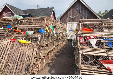 Lobster traps and commercial fisherman bait sheds some with a tuna tail on them, on a wharf on Prince Edward Island, Canada.