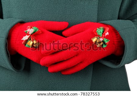 A pair of warm winter knit gloves festively decorated with Christmas bells and bows.