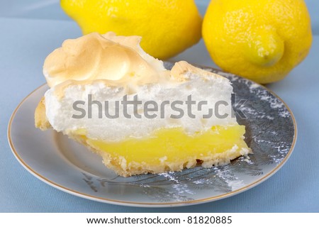 Close up of a slice of homemade lemon meringue pie on an antique plate.