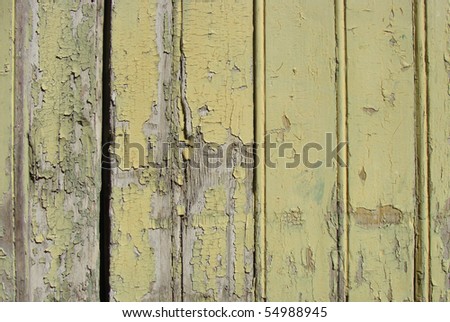 yellow painted worn wooden planks from a door gate