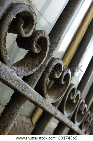 elegant rusty ionic curls on a metal window protective grid
