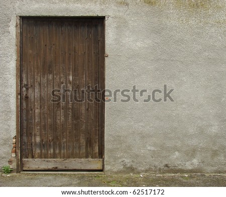 old brown wooden door embedded in a gray concrete wall