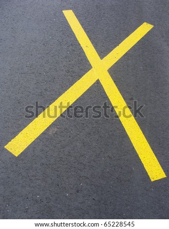 sidewalk with bright yellow paint cross on road
