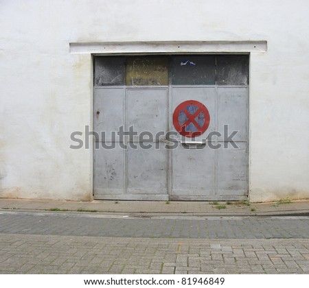 gray grungy metal garage door with side-walk