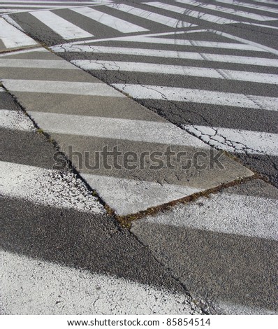 multiple white paint traffic patterns on asphalt road