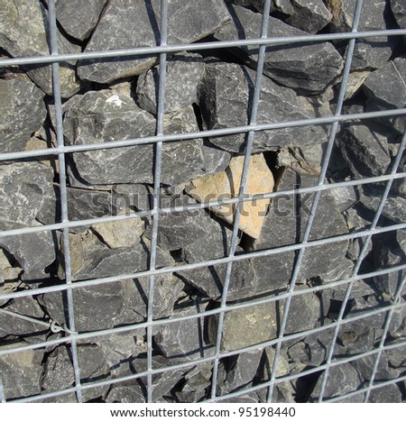 detail of fence wall made of stones in metal cage