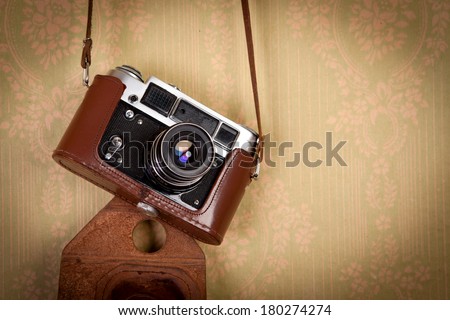 Retro vintage style camera on a old wallpaper