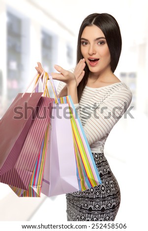 Shopping young beautiful happy girl with colored bags