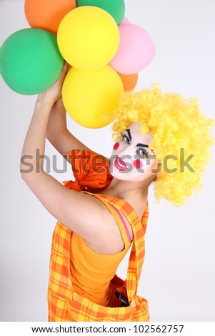 Funny clown in costume with colorful balloons