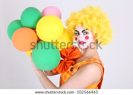 Funny clown in costume with colorful balloons