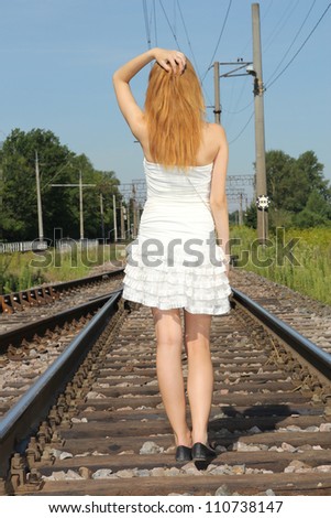 young woman in white dress on the railway