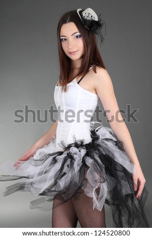 Young woman in ballet dress over grey