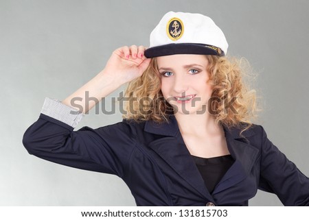 young woman in captain cap over grey