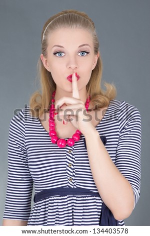 attractive pinup girl in striped dress with finger on her lips
