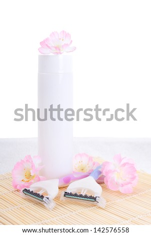 disposable razors, lotion and flowers over white