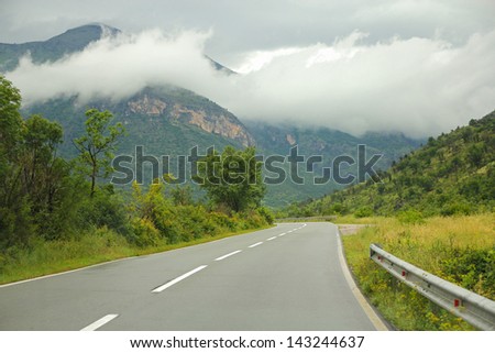 road to mountains and beautiful clouds on the sky