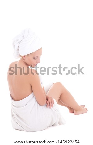 back-view of a young woman in towel sitting on white background
