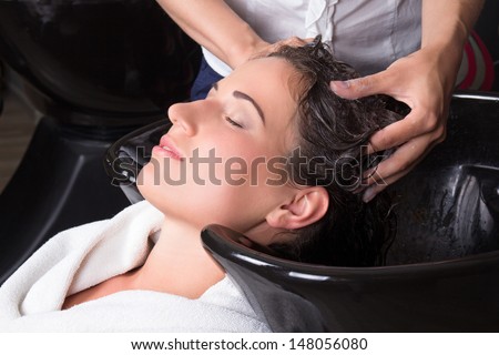 young attractive woman getting a hair wash in beauty salon