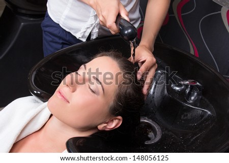 young beautiful woman getting a hair wash in beauty salon