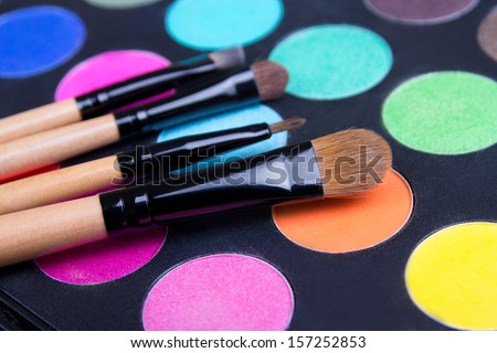 Make-up colorful eyeshadow palette and brushes over black
