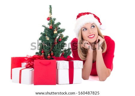 Dreaming woman lying down with christmas tree and gifts isolated on white background