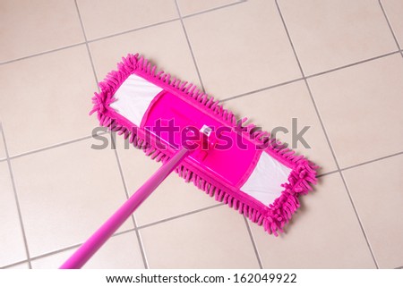 Tile floor washing with a mop in bathroom