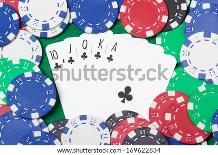 close up of a royal flush combination at poker with chips on the green casino table