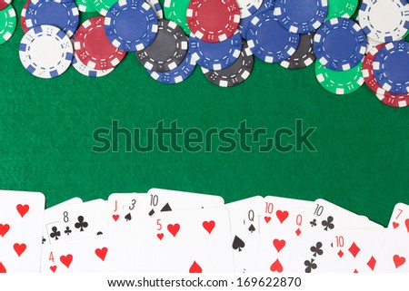 poker chips and cards on a green casino table background