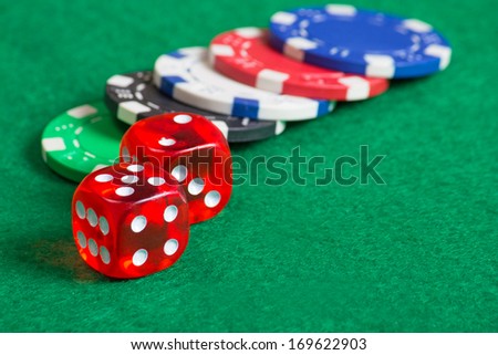 red dice on a casino table with colorful chips