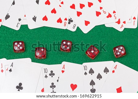 close up of playing cards and red dices on the green casino table