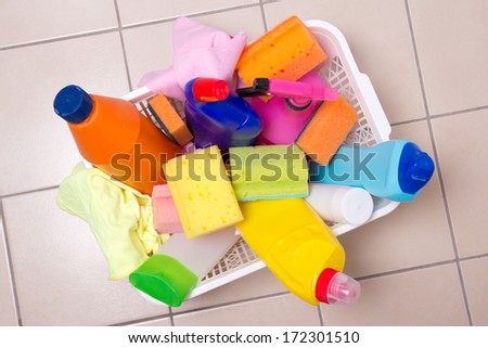 full box of cleaning supplies on tiled floor in bathroom